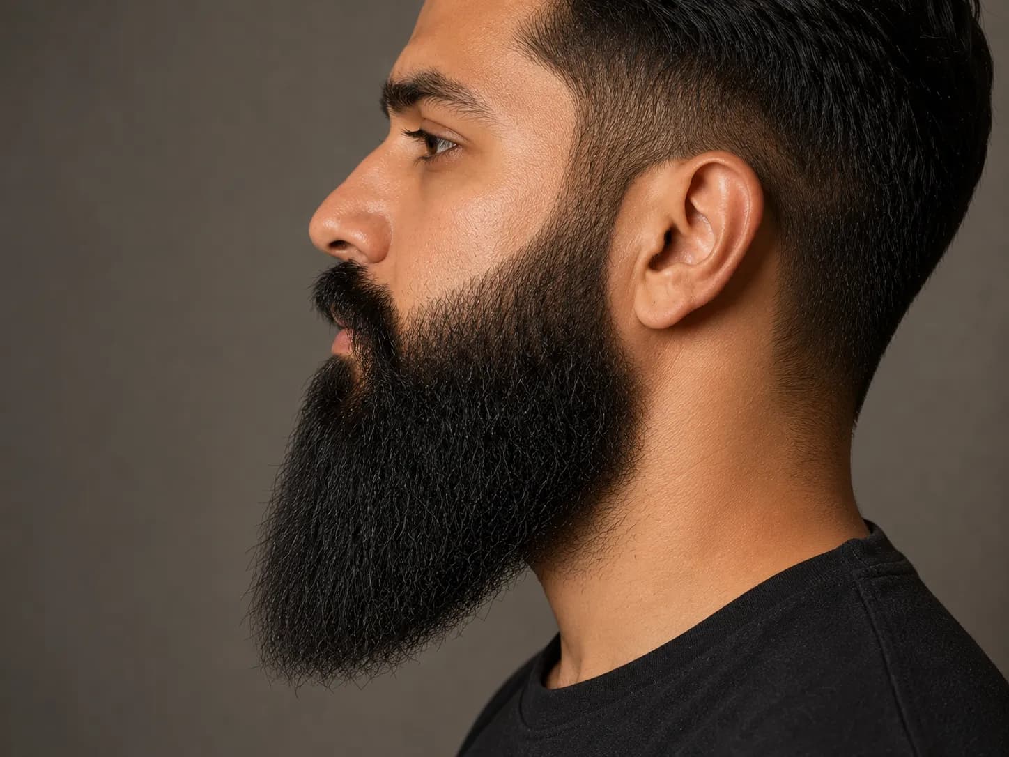 Left side profile of a long beard with shorter tapered sides blending smoothly into a fuller chin, demonstrating the ideal shape for trimming and maintaining a long beard.